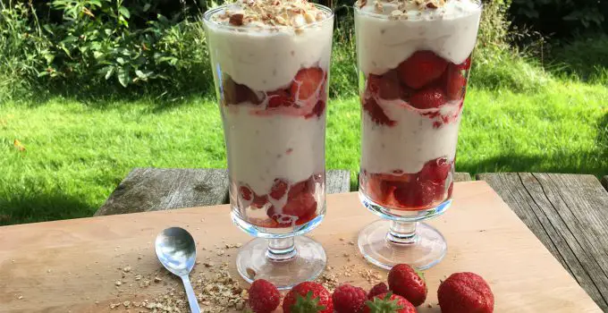 Sommerdessert med friske jordbær og hindbær serveret i høje glas