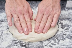 sådan trykker du en pizzadej ud.