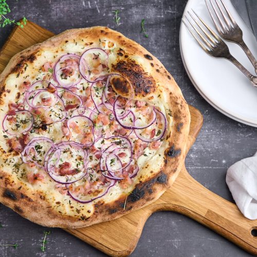 tarte flambee eller flamkuchen med creme fraiche, løg og bacon samt timian.