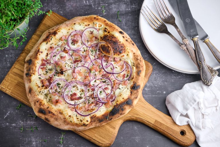 tarte flambee eller flamkuchen med creme fraiche, løg og bacon samt timian.