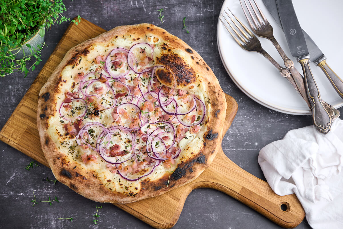 tarte flambee eller flamkuchen med creme fraiche, løg og bacon samt timian.