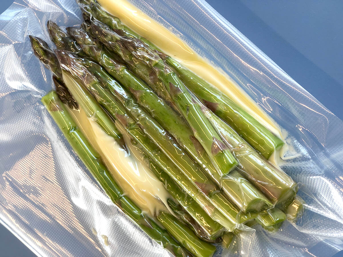 Grønne asparges sous vide med smør i posen.