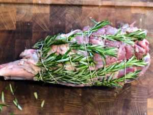 Lammekølle der er bundet op med rosmarin og hvidløg og klar til grillen.