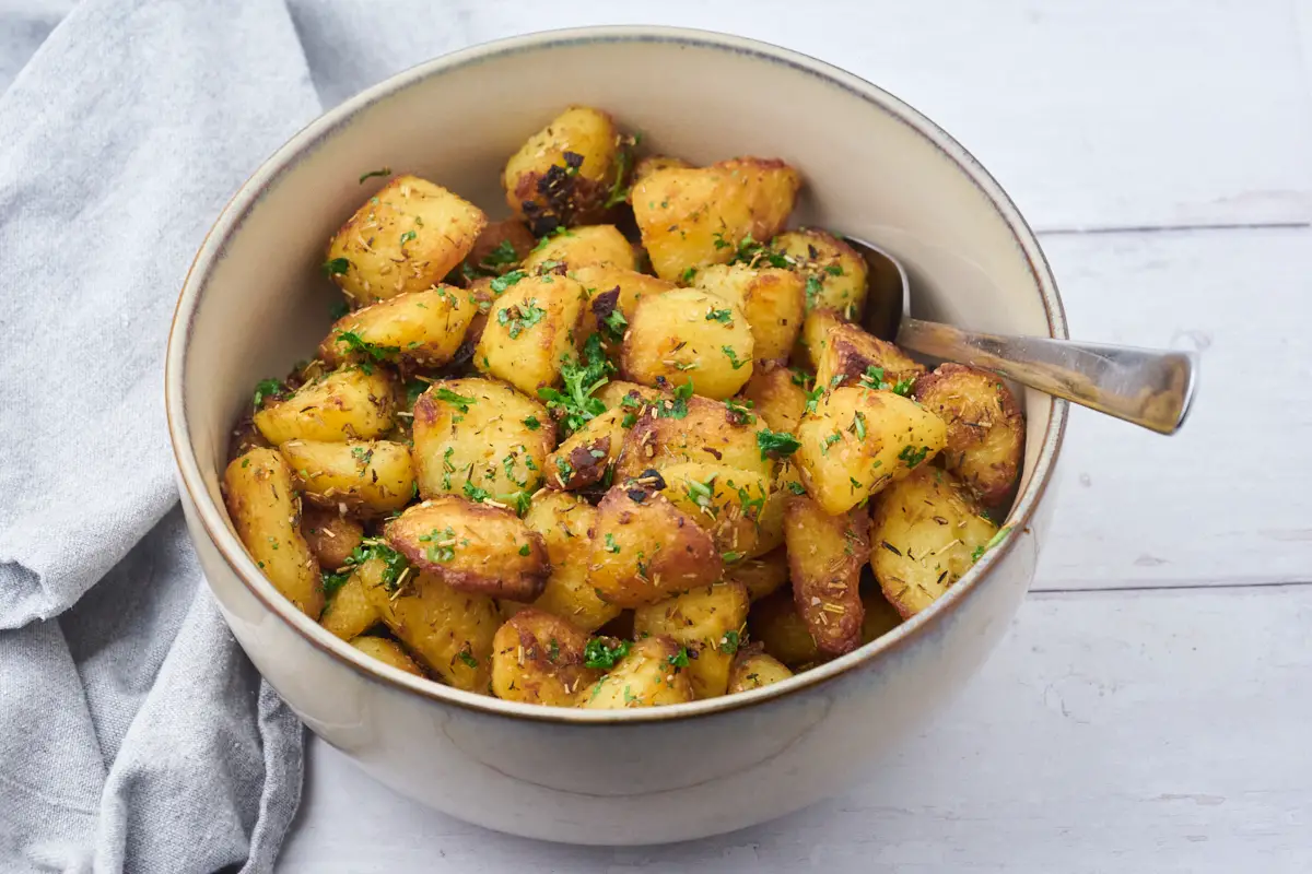 sprøde kartofler i ovn drysset med frisk persille.