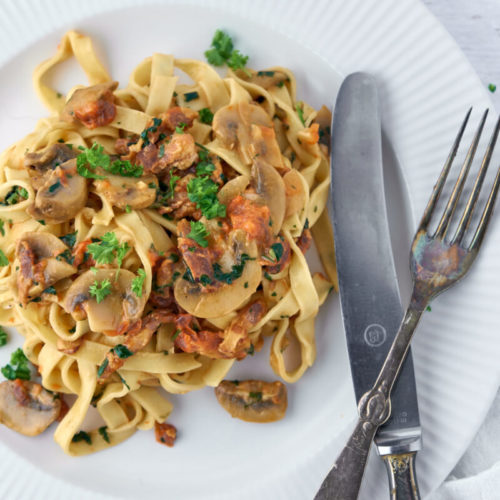 Pasta med tomatsovs, champignon og persille på toppen.