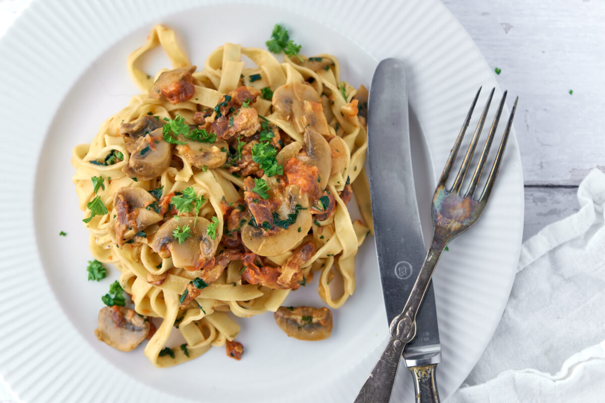 Pasta med tomatsovs, champignon og persille på toppen.