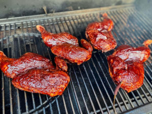 Halve kyllinger på grillen med bbq sovs.