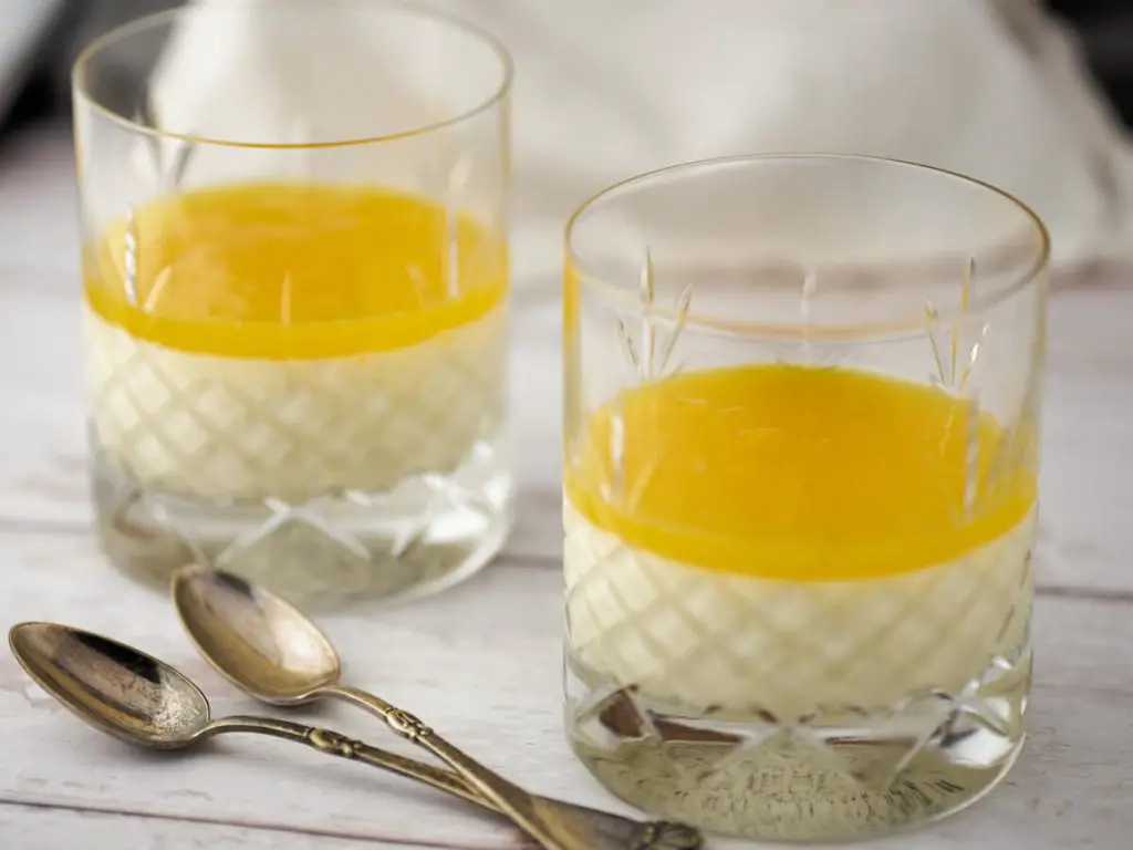 Panna cotta i glas med mango gele på toppen og to skeer