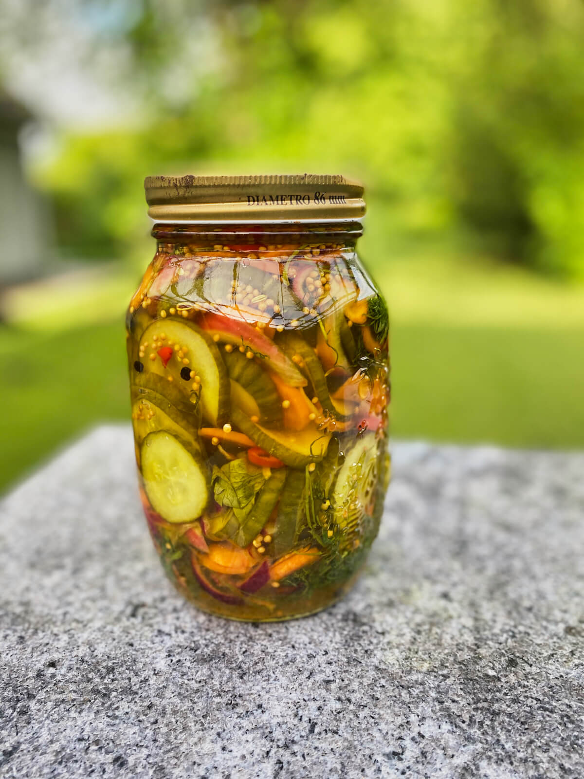 Glas med syltede gulerødder og agurker med chili.