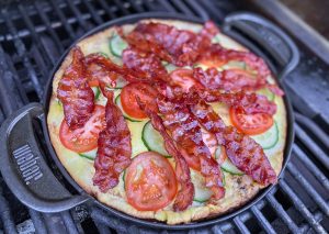 Æggekage der står på grillen i en støbejernspande.