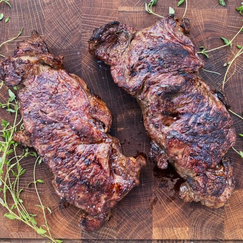 Færdige grillede entrecote bøffer på skærebræt.