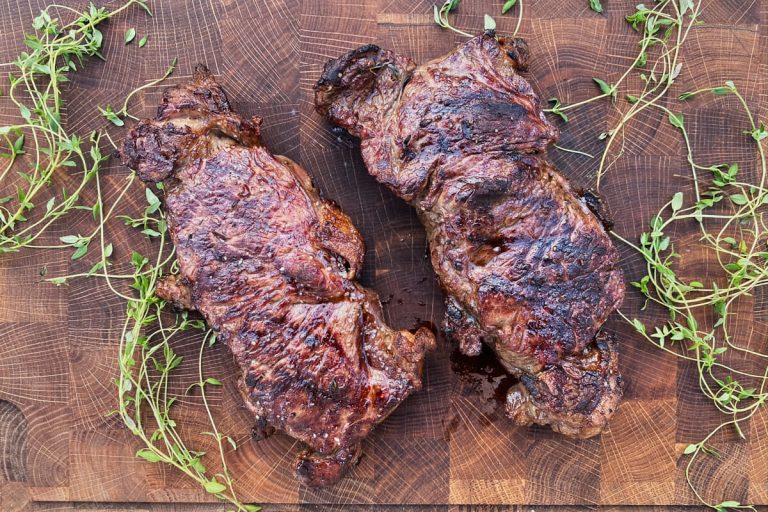 Færdige grillede entrecote bøffer på skærebræt.