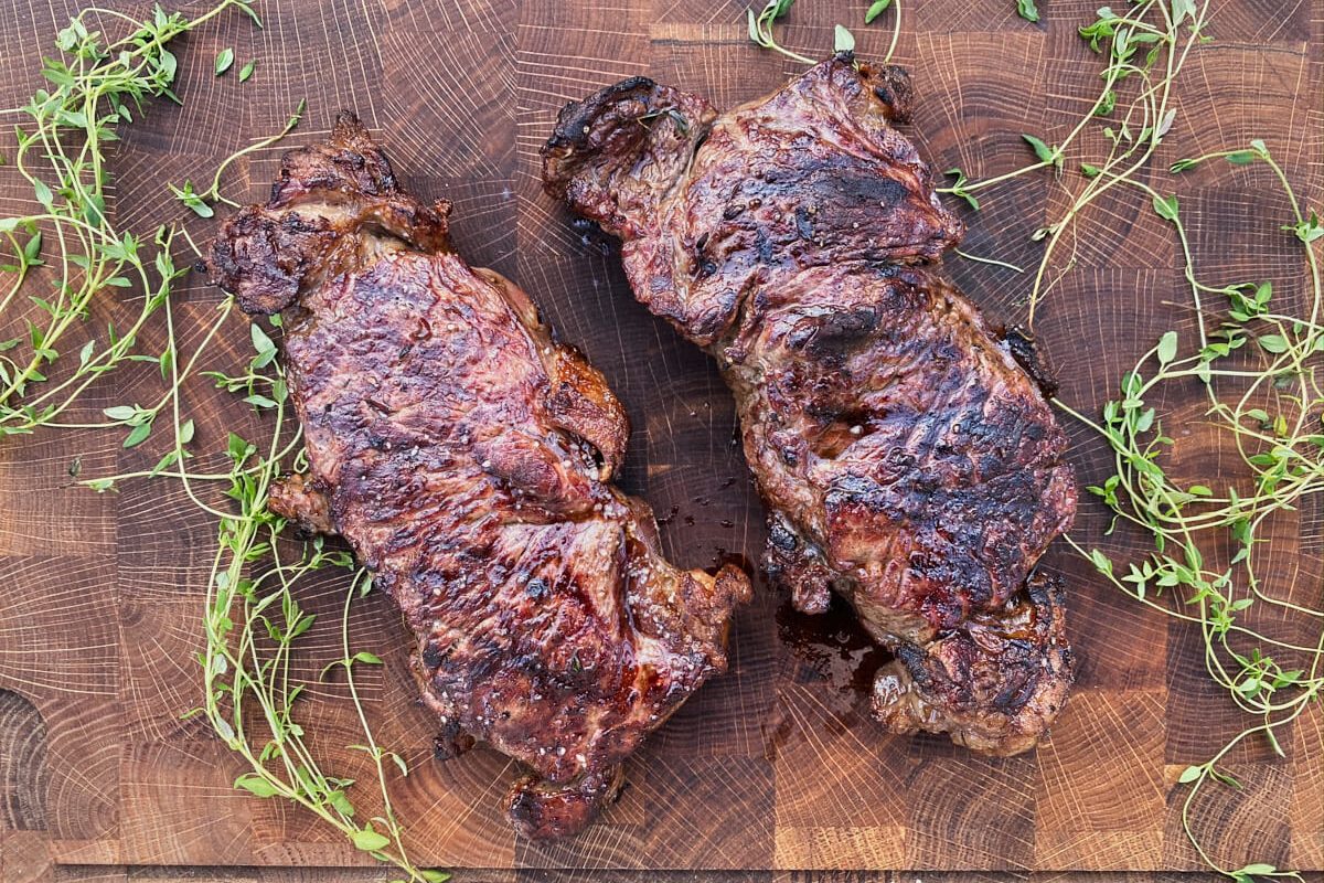 Færdige grillede entrecote bøffer på skærebræt.