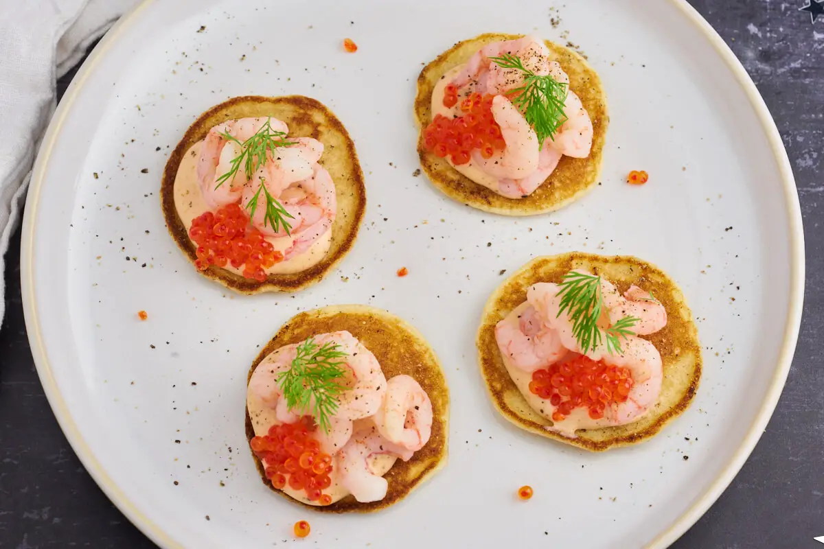 4 blinis med rejer og kaviar på tallerken