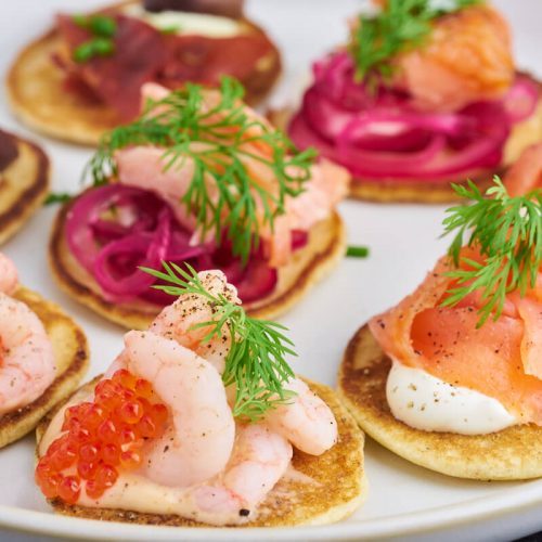 Små blinis pandekager og forslag til blinis fyld med rejer, laks og parmaskinke