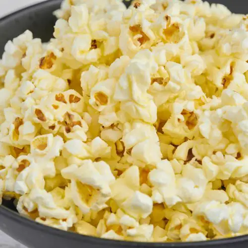 popcorn med smør i sort skål