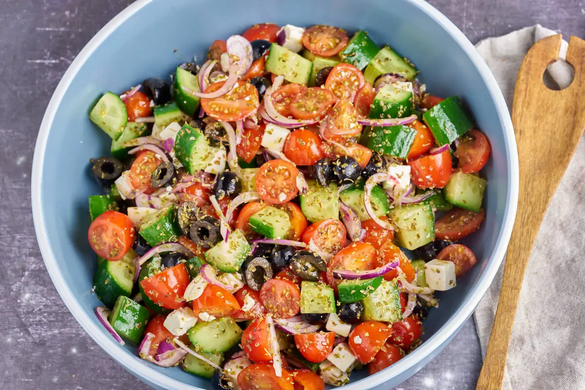 skål med græsk salat med agurk. tomat, rødløg og oliven
