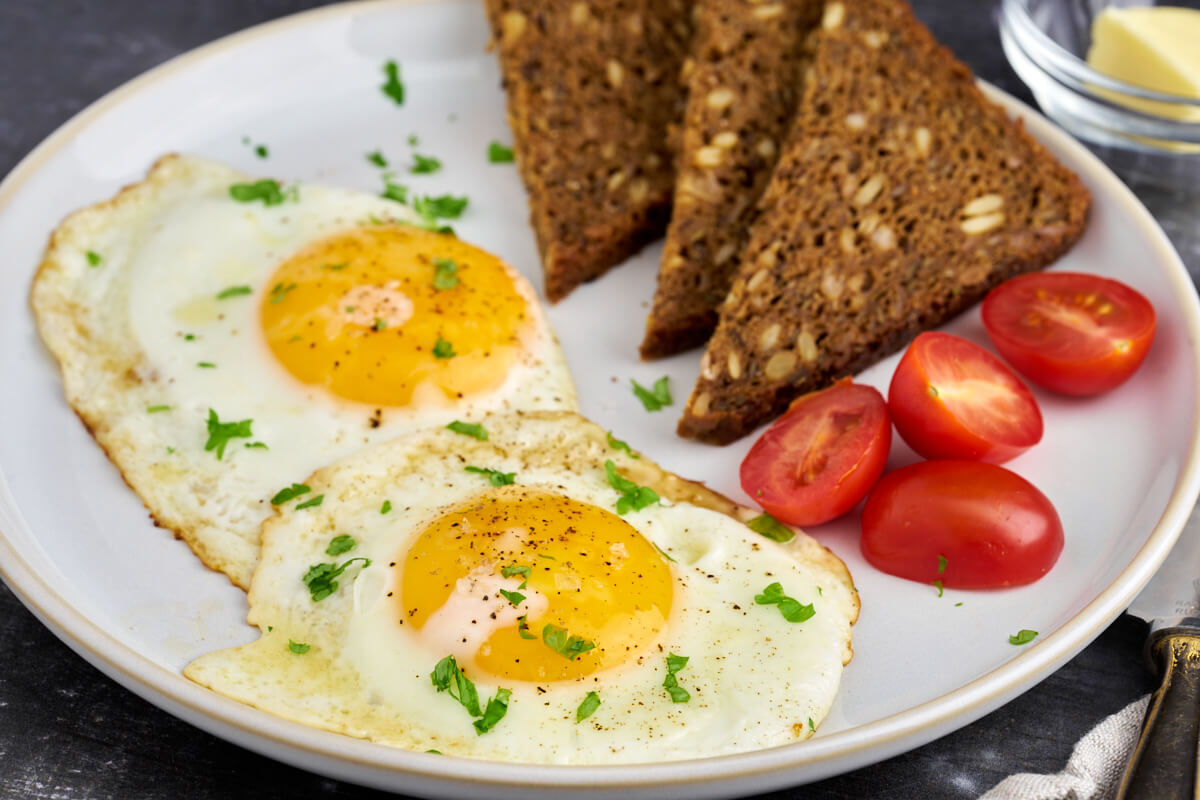 perfekte spejlæg til morgenmad, frokost eller aftensmad serveret med rugbrød og tomat