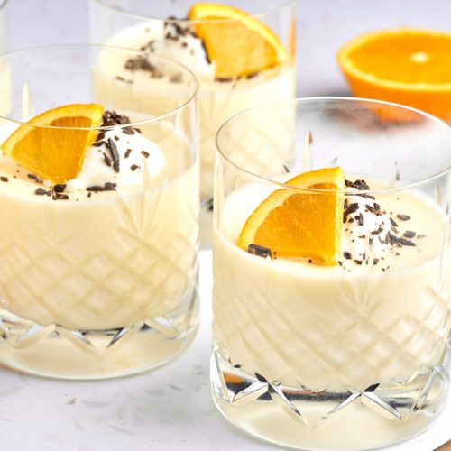 appelsinfromage i glas med flødeskum, appelsinskive og chokolade på toppen