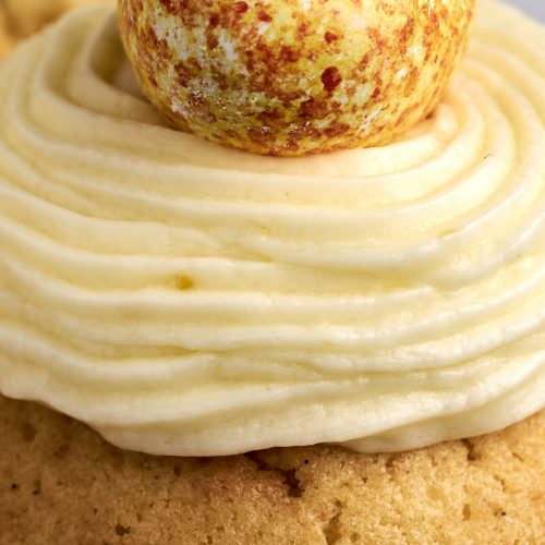 citronsmørcreme på toppen af en cupcake med påskeæg på toppen