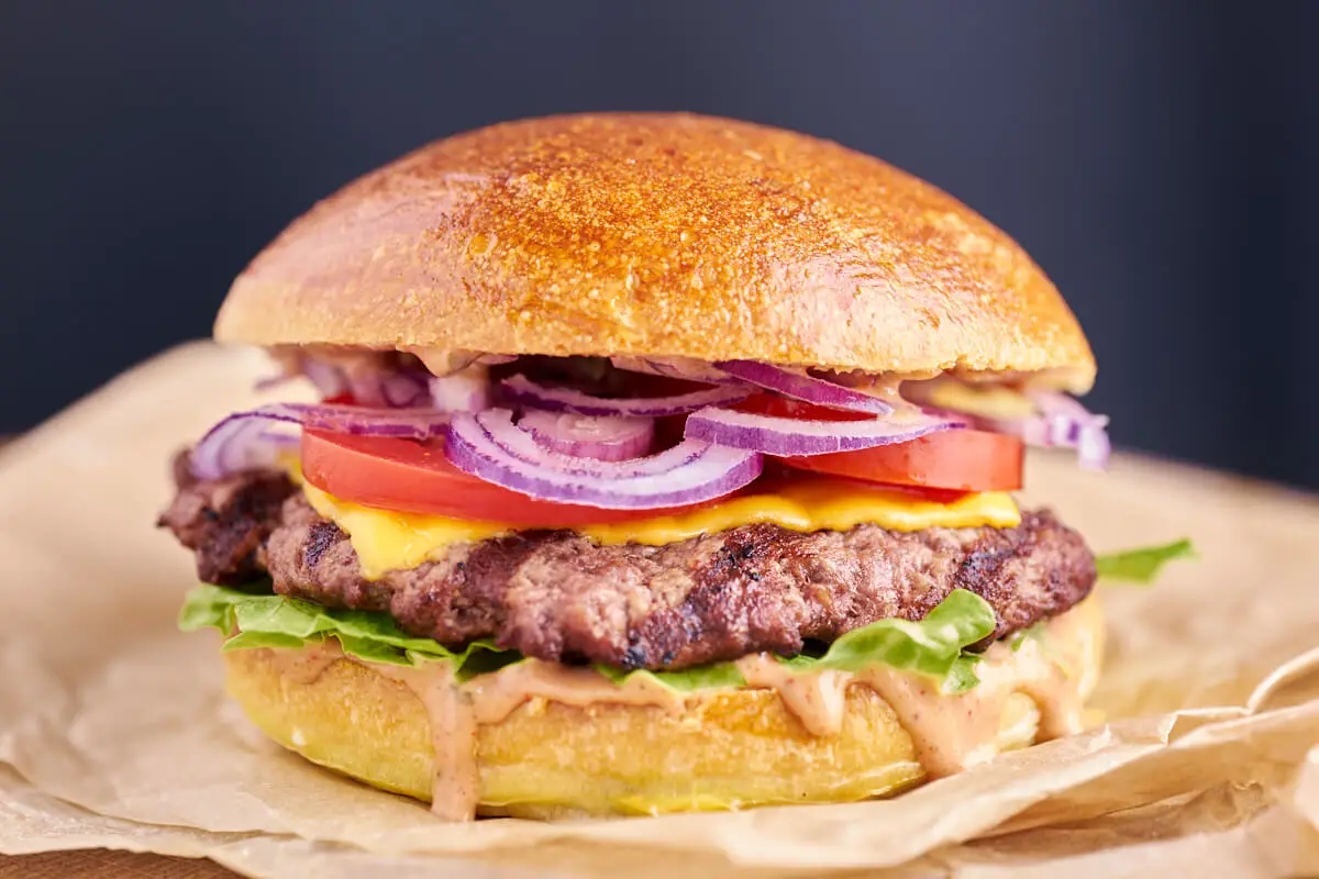 Lækker hjemmelavet burger med salat, burgerbøf med ost, tomat, rødløg og burgerdressing