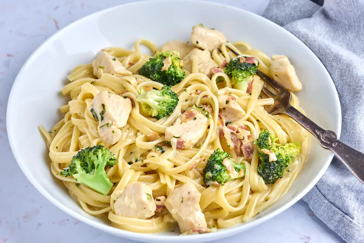 Tallerken med pasta med kylling og bacon samt broccoli i cremet flødesauce