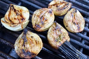 grillede løg der pensles med marinade.