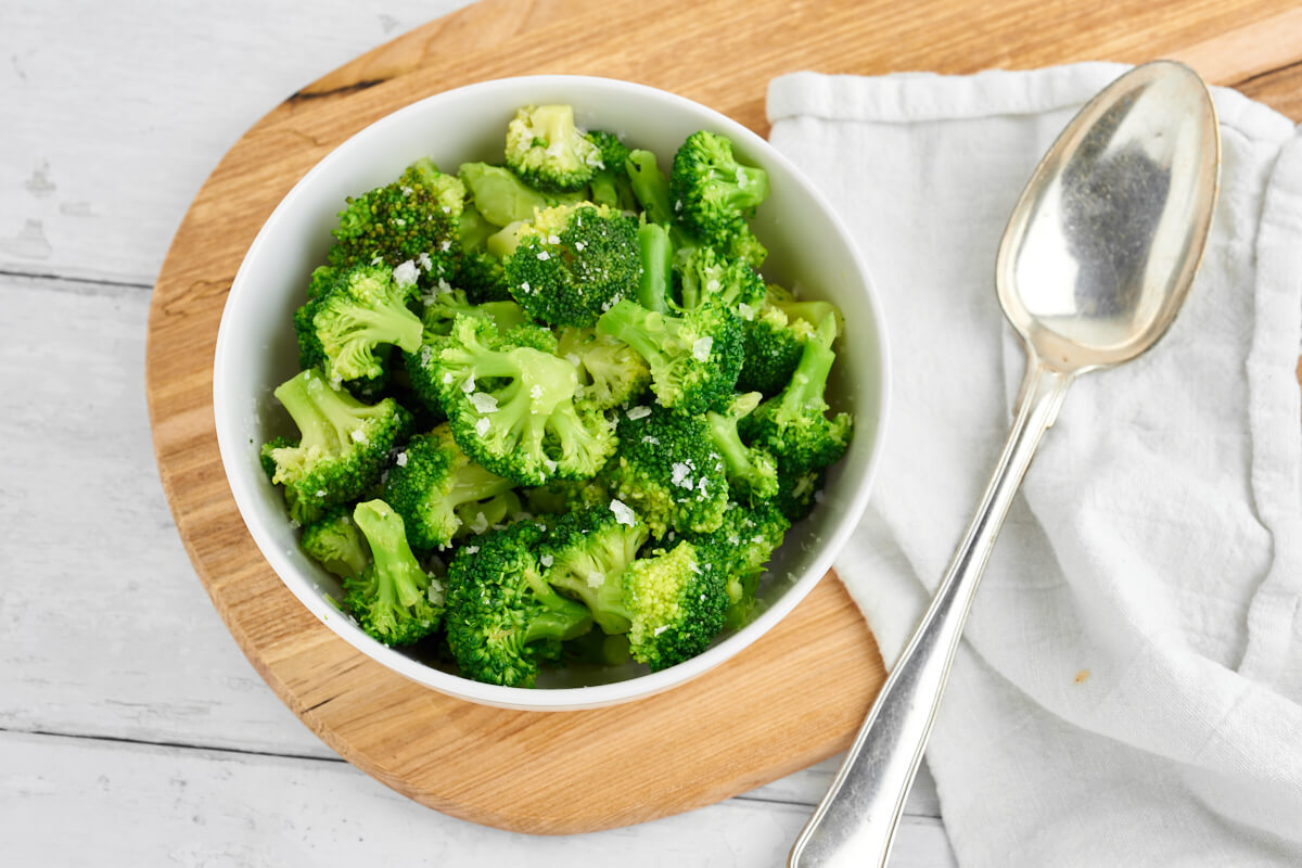 skål med kogt broccoli med flagesalt i hvid skål