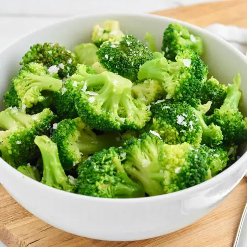 kogt broccoli i hvid skål drysset med flagesalt