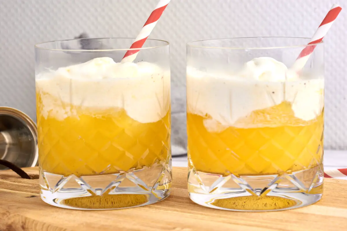 glas med københavnerstang drinks med ananasjuice og vaniljeis på toppen
