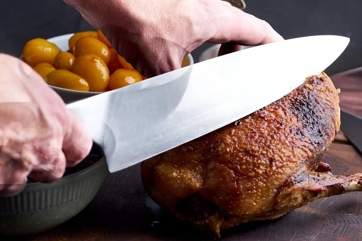 andebryststeg i ovn klar til servering med kniv der skærer i kødet
