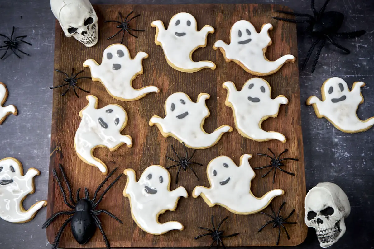 spøgelses halloween småkager med glasur på træbræt med edderkopper