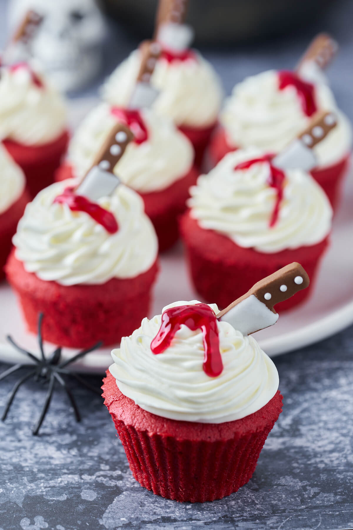 halloween kager i form af røde cupcakes med blod og kniv i cream cheese frosting