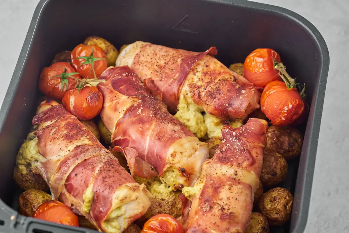 airfryer-kurv med kartofler, kylling og tomater