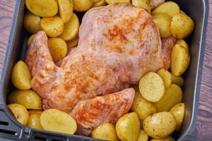 hel rå kylling og kartofler i airfryer.