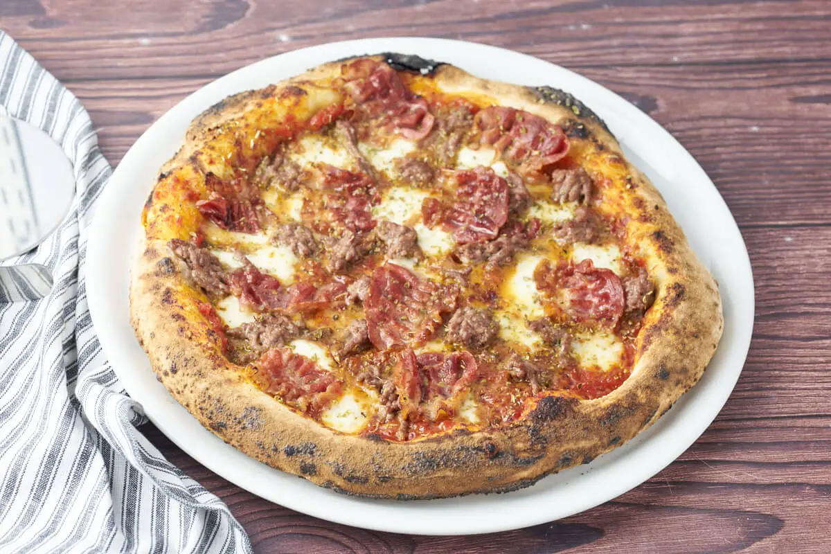tallerken med pizza med oksekød og bacon