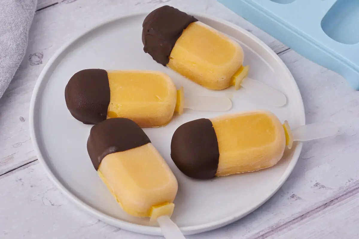 sunde ispinde med mango og mørk chokolade på tallerken