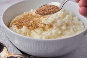 skål med risengrød hvor der drysses kanelsukker over.