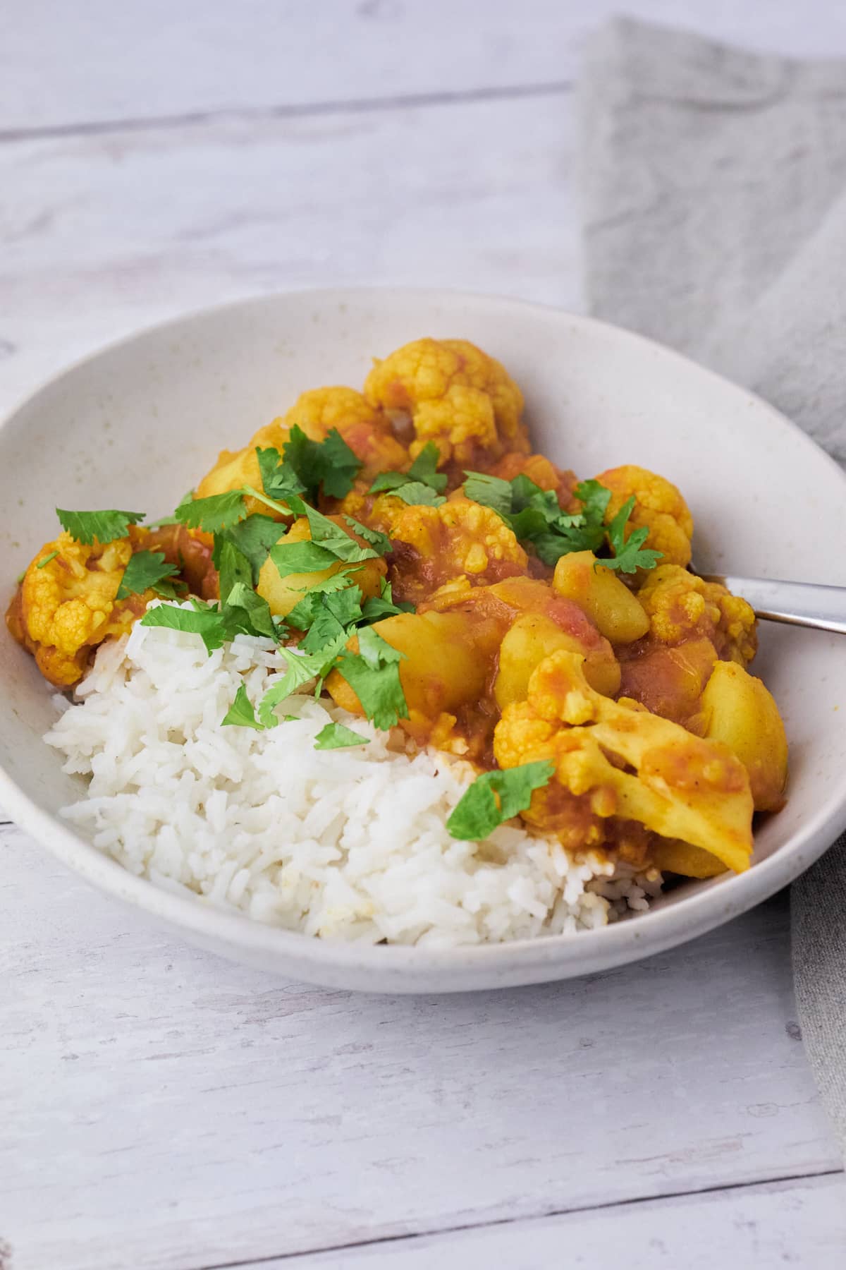 tallerken med Indisk Aloo gobi med kogte ris til.