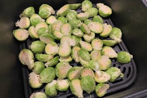 rå rosenkål i airfryer kurv klar til at komme i airfryeren.