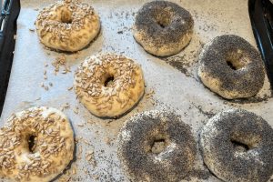 bagels med frø og kerner på toppen klar til at komme i ovnen.