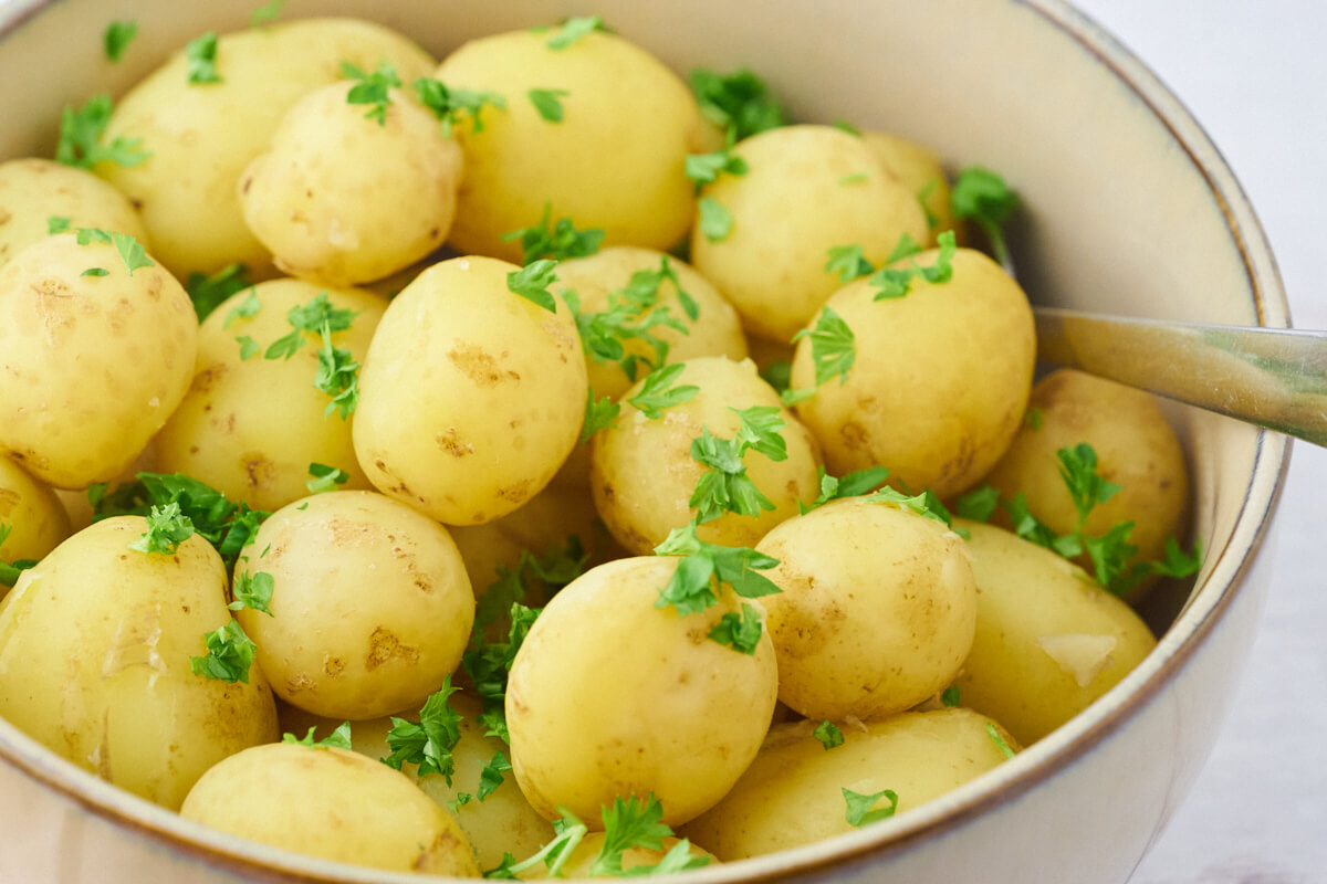kogte kartofler med persille i skål.
