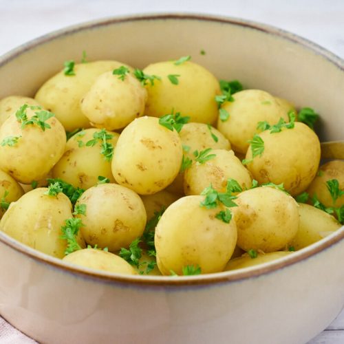 kogte nye kartofler med persille i serveringsskål.