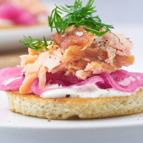 ristet brød med varmrøget laks, syltede rødløg og creme fraiche som forret.