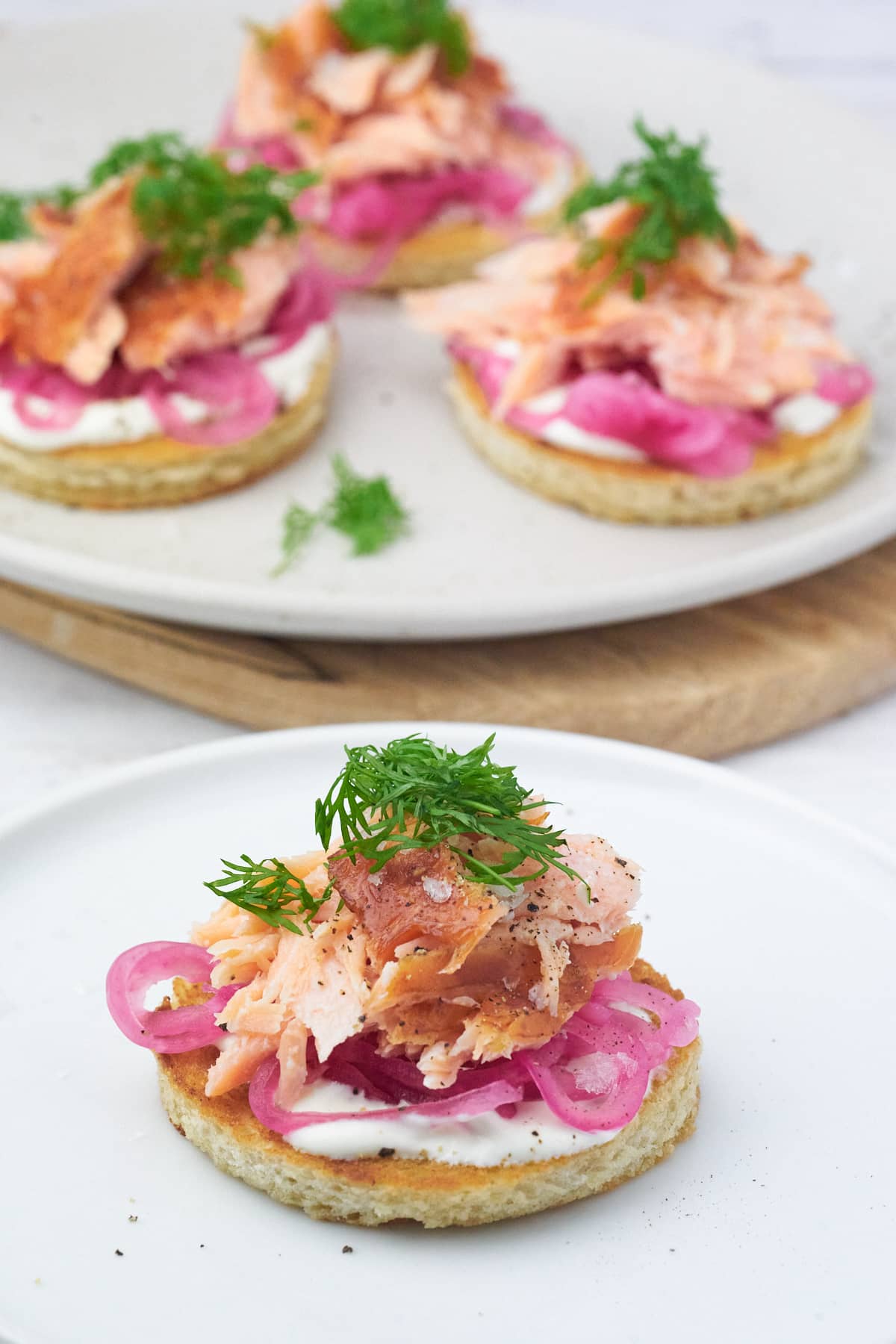 4 forretter med brød, varmrøget laks og syltede rødløg.