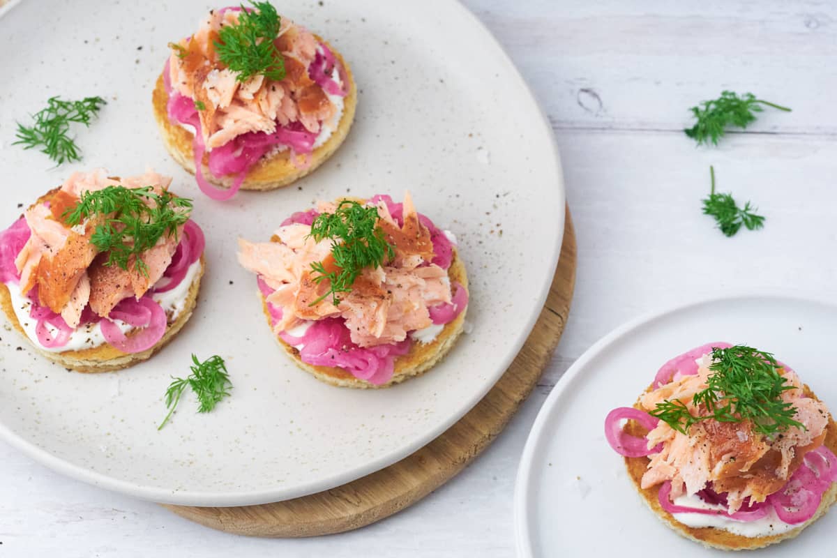 Servering med 4 forretter med ristet brød og varmrøget laks til nytår.