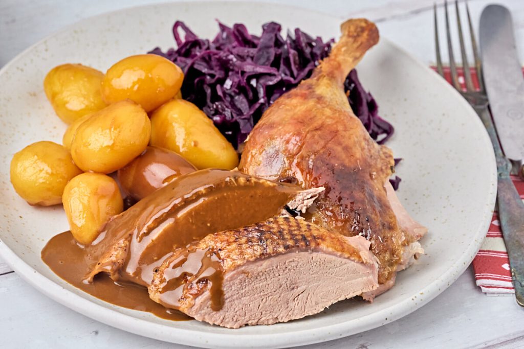 Andesteg med brunede kartofler, rødkål og sovs.