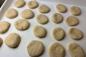 berlinere der er stukket ud af udrullet dej.