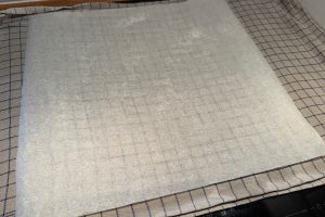 forberedt fugtigt viskestykke med bagepapir og sukker.