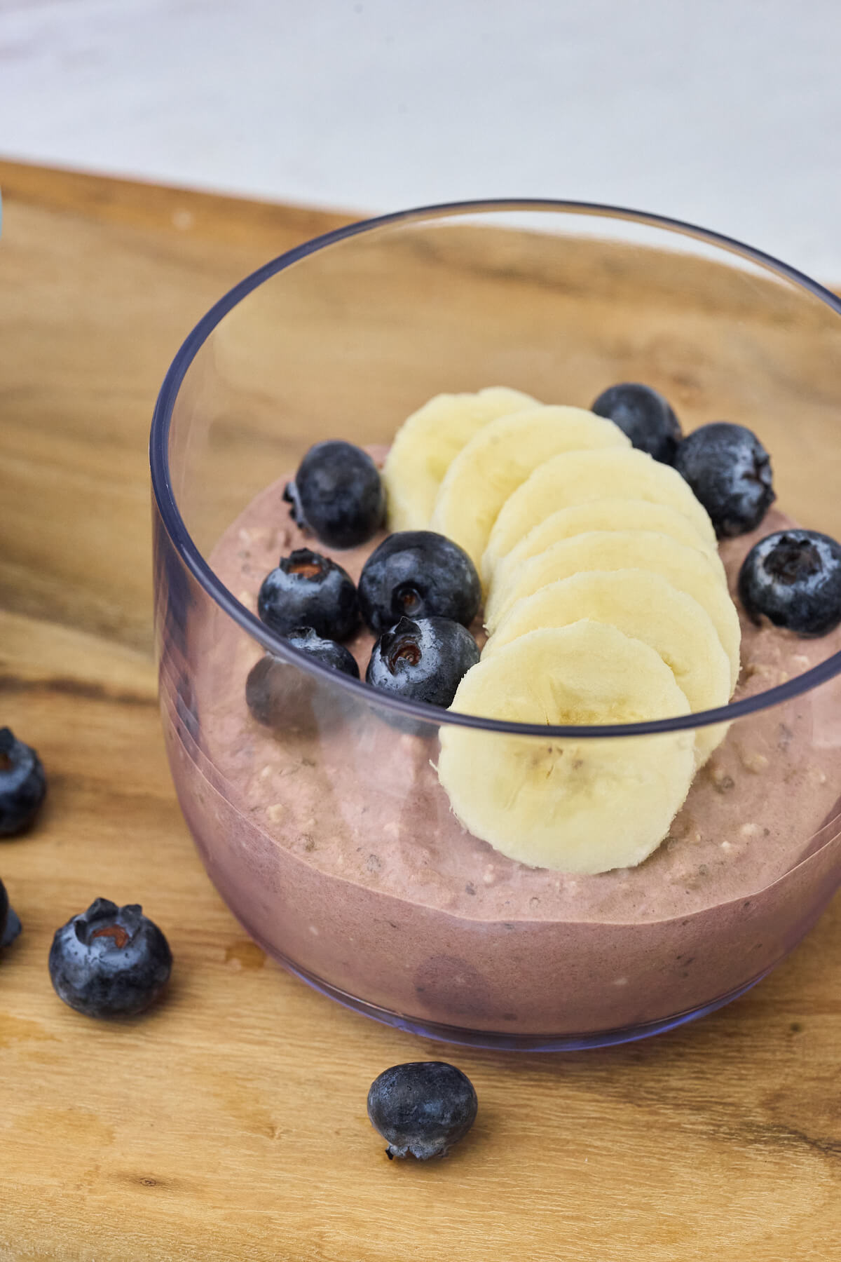 glas med overnight oats med kakao toppet med frisk frugt og bær.